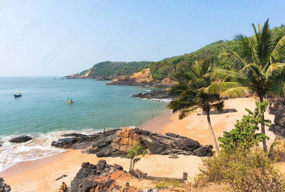 Paradise beach in Gokarna. Beautiful deserted landscape with clean sand and wave. View from the sea to the shore.